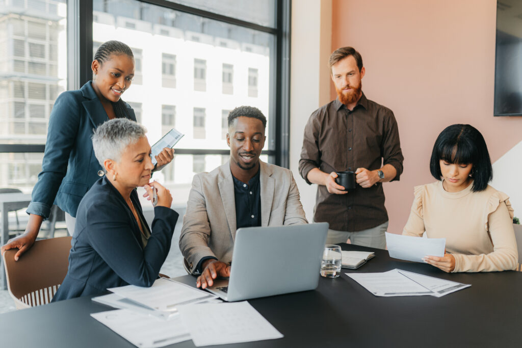 diverse team analyzing staffing website design trends on a laptop.