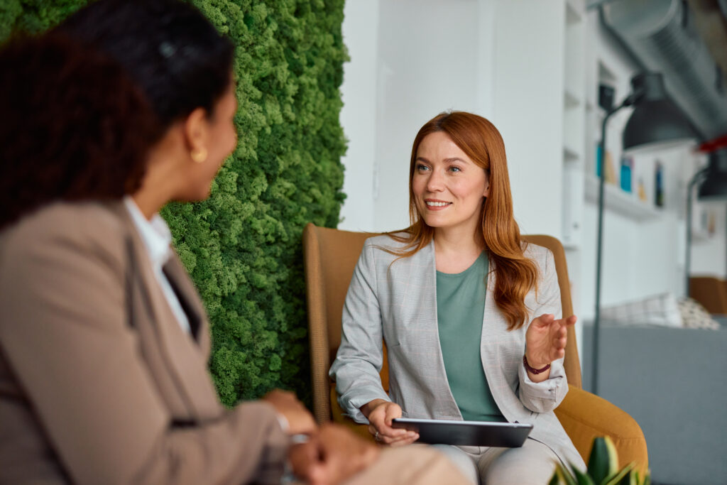 two businesswomen discussing saas talent acquisition strategies, leveraging staffing websites for recruitment in 2026.
